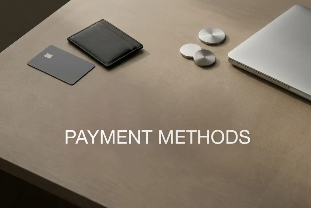 Blank payment card, neutral wallet and abstract coin shapes beside a laptop on a desk